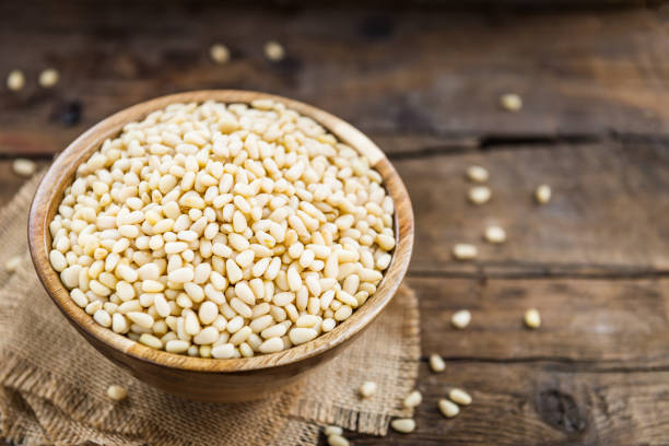 istock Shelled Raw Pine Nuts in the Wooden Bowl 939779028