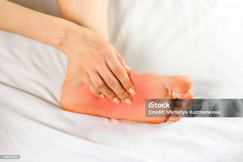 Pain in the foot sole. Bad leg. The focus of pain is marked in red. Close up Pain in the foot sole. Bad leg. The focus of pain is marked in red. Close up. Diabetes Stock Photo