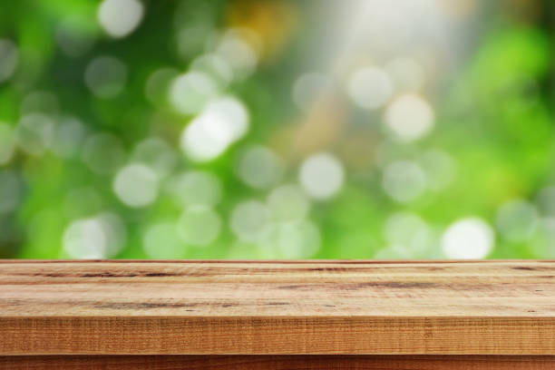 istock Blurred green bokeh background and wooden table. 939780942