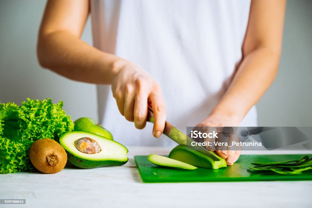 woman cut avocado. healthy food concept. ingredients for smoothies Avocado Stock Photo