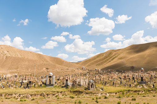 Muslim cemetery with tombstones and domes against very scenic backgrounds of hills and blue sky.