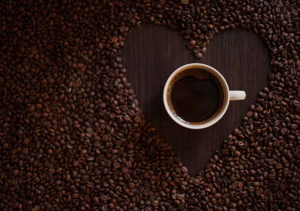 istock Coffee cup and coffee beans on wooden table 939790574