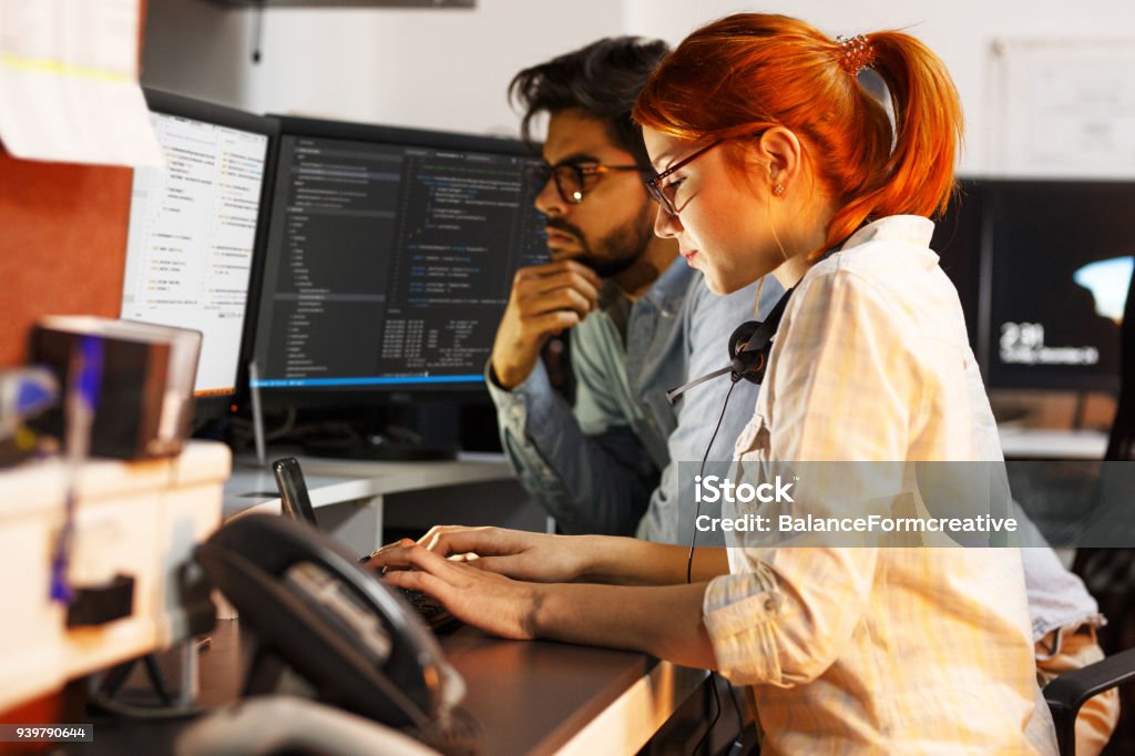 Two programmers working on new project.They working late at night at the office. Computer Programmer Stock Photo