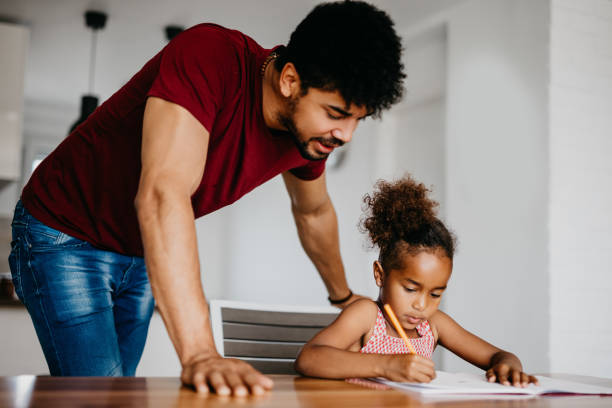 istock Man supervises his daughter doing homework. 939790710