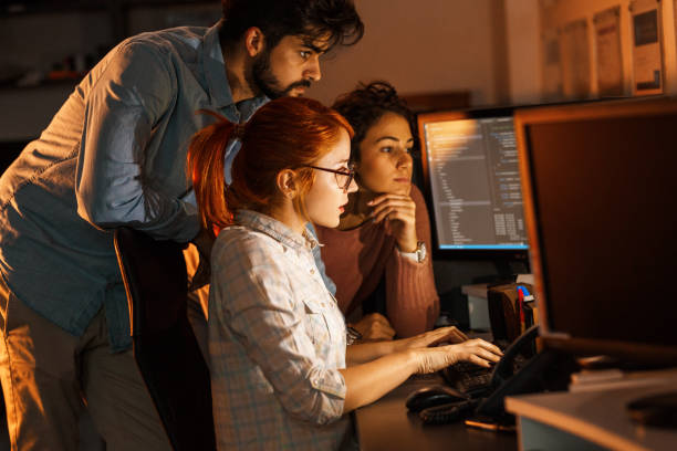 Team of programmers working on new project.They working late at night at the office.