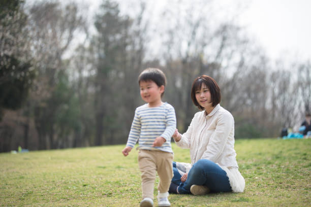 istock Mother and child relaxing and playing in park 939790886
