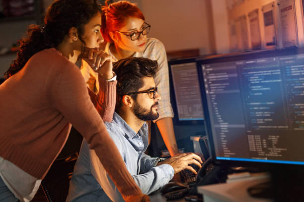 istock Team of programmers working on new project.They working late at night at the office. 939790938