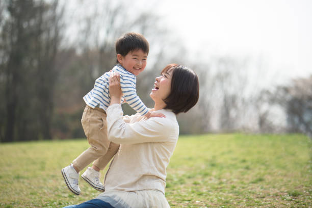 istock Mother and child relaxing and playing in park 939790944