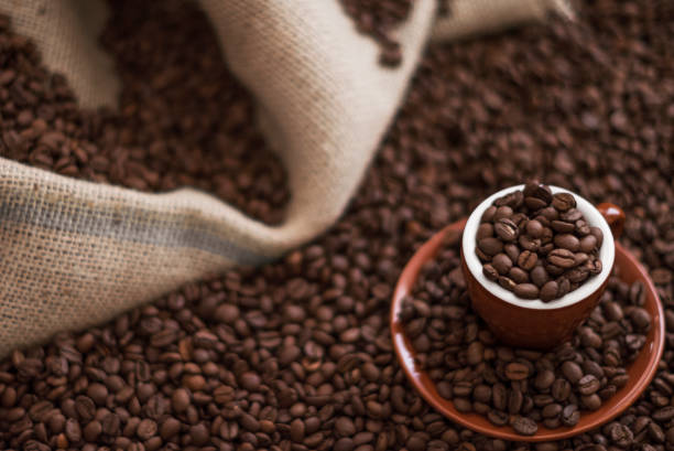 istock Coffee cup and coffee beans on wooden table 939790976