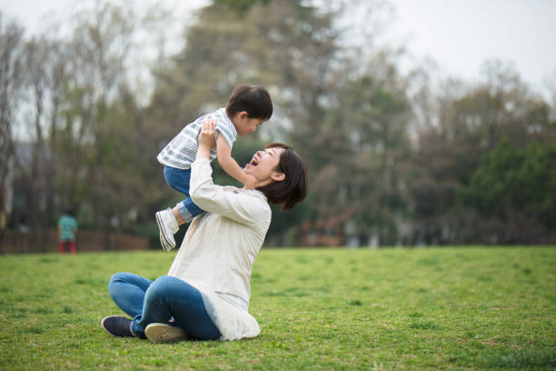 Mother and child relaxing and playing in park