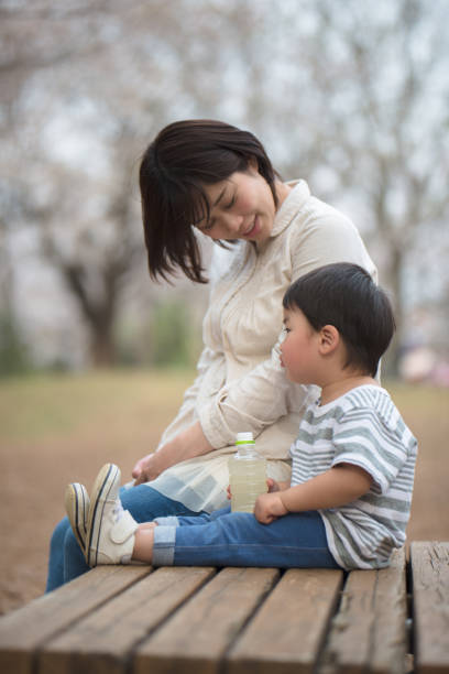 istock Mother and child sitting on bench and talking 939791950