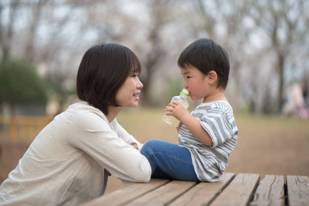 Mother and child sitting on bench and talking
