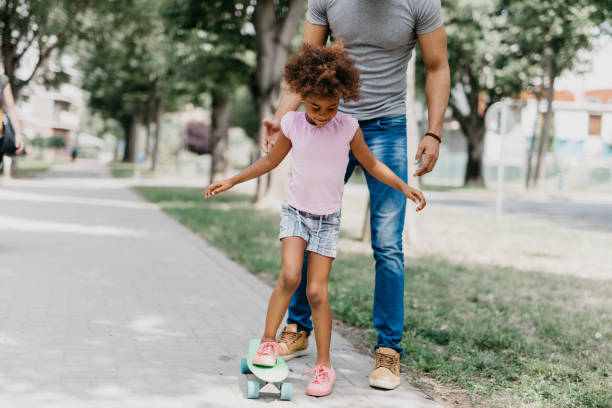 istock Adorable child learning to ride penny board. 939795552