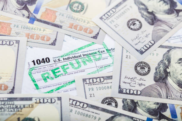 IRS Tax form 1040 A stock photo of the IRS Tax form 1040. Please note the money in this photo is marked with the words "For Motion Picture use only" Property release provided. one hundred dollar stamp stock pictures, royalty-free photos & images