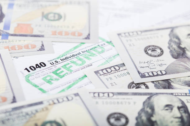 IRS Tax form 1040 A stock photo of the IRS Tax form 1040. Please note the money in this photo is marked with the words "For Motion Picture use only" Property release provided. one hundred dollar stamp stock pictures, royalty-free photos & images