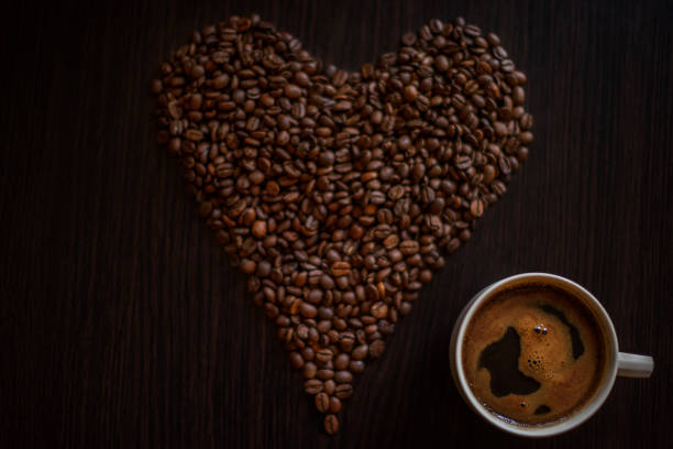 istock Coffee cup and coffee beans on wooden table. 939798478