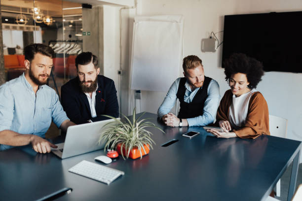 istock Multi-ethnic group of creative young business people are using laptop at work. 939803058