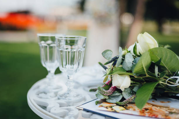 istock Wedding bouquet with glasses on the ceremony table 939806432