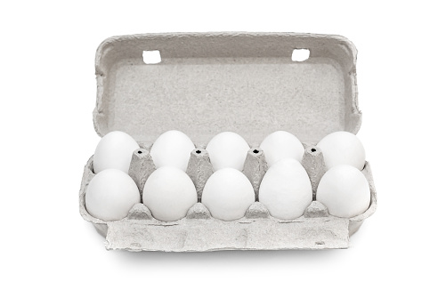 White eggs in open carton container on white background.