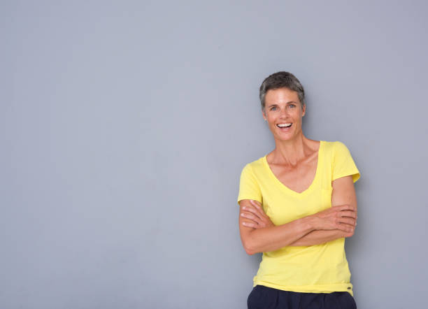 istock confident older woman smiling against gray background 939808818