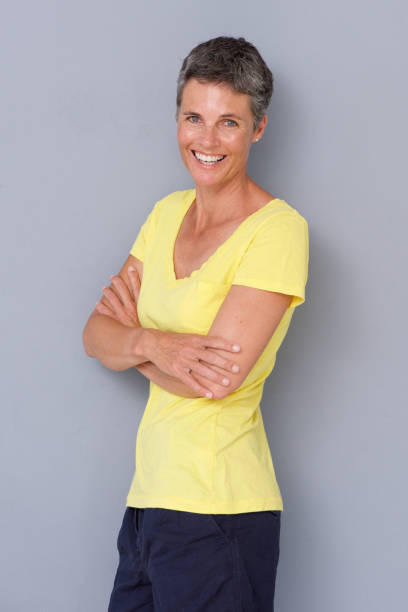 istock happy woman smiling against gray background 939808826