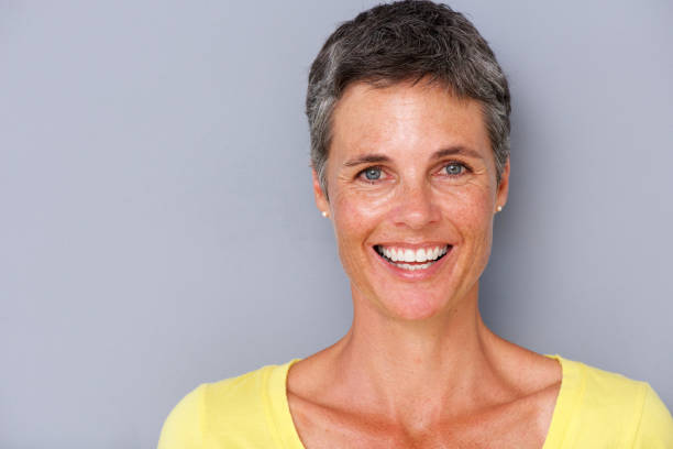 istock Close up attractive middle age woman smiling against gray background 939808848