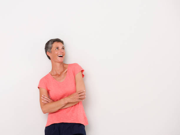 istock smiling middle age woman against white wall 939808910