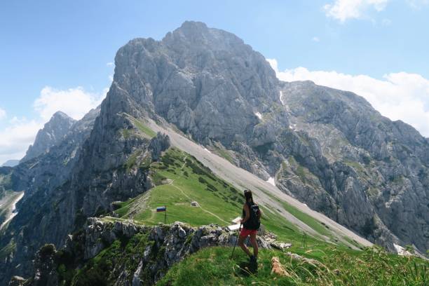 istock Young woman standing on the edge / mountains 939822338