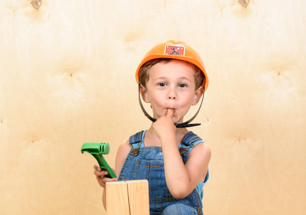 Dog wearing hardhat and dungarees at construction site