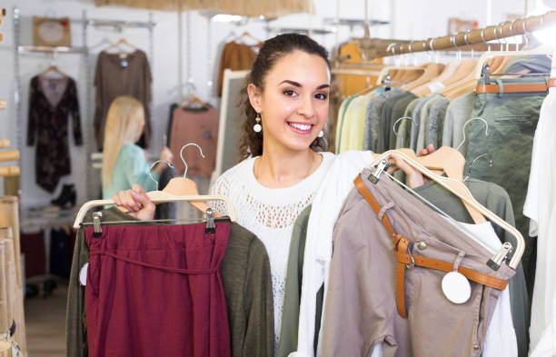 istock Girl selecting new garments at the store 939826436