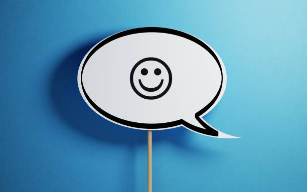 White Chat Bubble With A Wooden Stick On Blue Background White chat bubble with a wooden stick on  blue background. There is a smiley face symbol on chat bubble. Horizontal composition with copy space. smiley face postit stock pictures, royalty-free photos & images