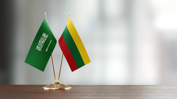 istock Saudi Arabian And Lithuanian Flag Pair On A Desk Over Defocused Background 939833224