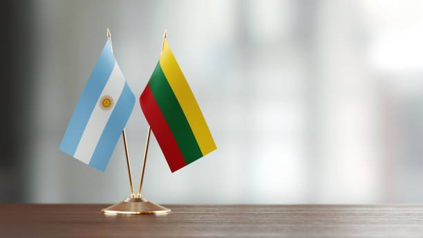 istock Argentinian And Lithuanian Flag Pair On A Desk Over Defocused Background 939833278
