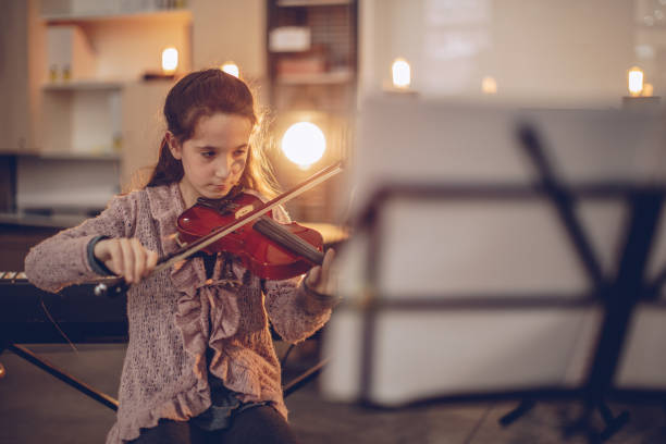 istock Cute girl playing violin 939833306