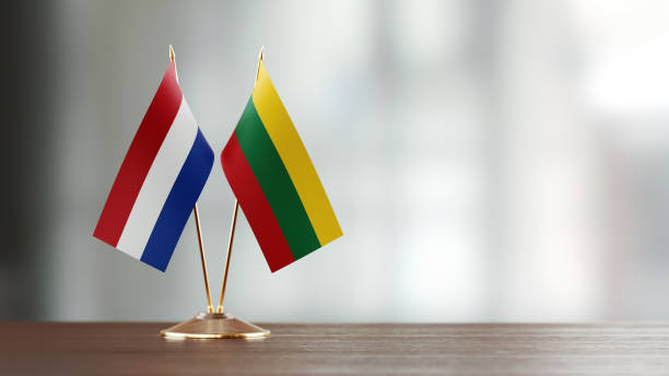 istock Dutch And Lithuanian Flag Pair On A Desk Over Defocused Background 939833544