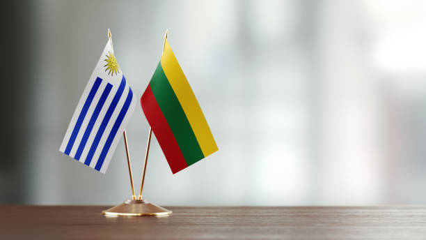 istock Uruguayan And Lithuanian Flag Pair On A Desk Over Defocused Background 939834306