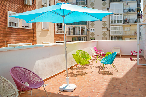 Chairs and sunshade umbrella at the patio of a hostel in Malaga Andalusia Spain.