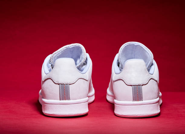 istock White Tennis Shoe - Red Background 939840282