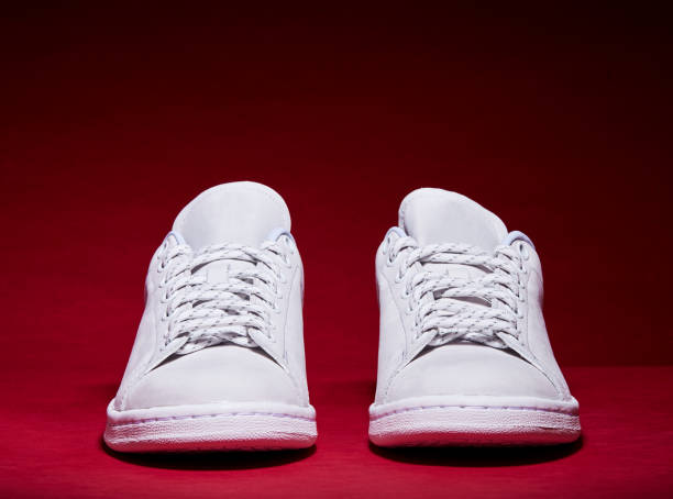 istock White Tennis Shoe - Red Background 939840284