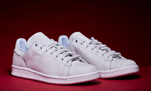 istock White Tennis Shoe - Red Background 939840286