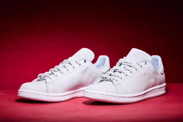 istock White Tennis Shoe - Red Background 939840288