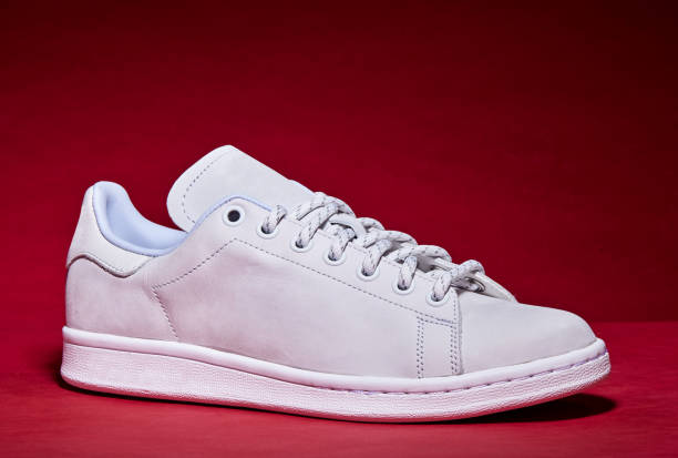 istock White Tennis Shoe - Red Background 939840292