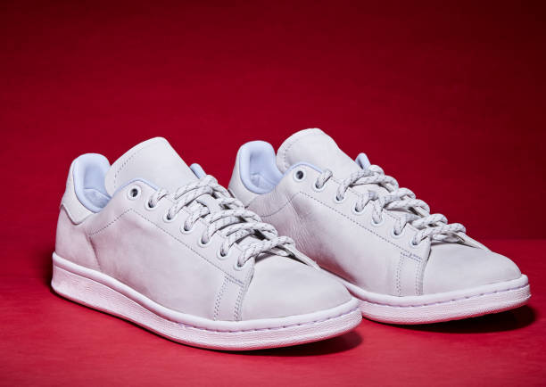 istock White Tennis Shoe - Red Background 939840298