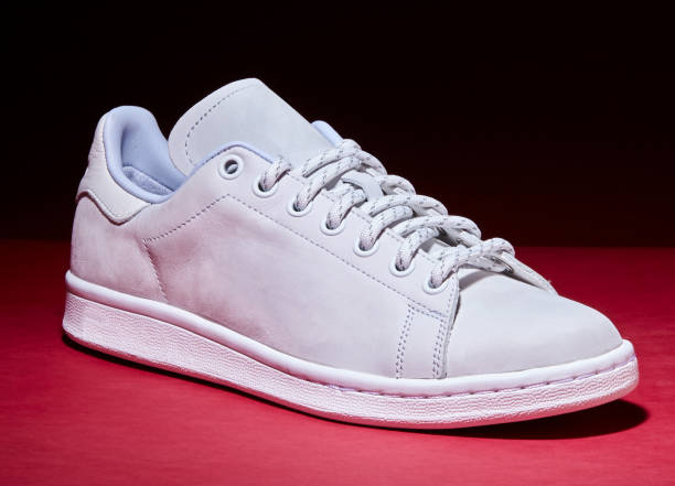 istock White Tennis Shoe - Red Background 939840300