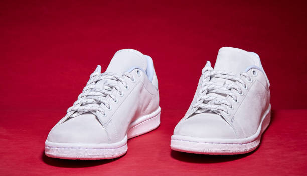istock White Tennis Shoe - Red Background 939840302