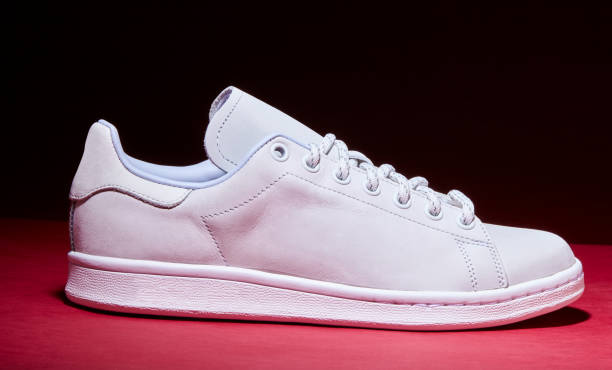 istock White Tennis Shoe - Red Background 939840304