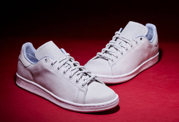 istock White Tennis Shoe - Red Background 939840308