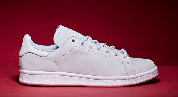 istock White Tennis Shoe - Red Background 939840314
