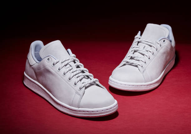 istock White Tennis Shoe - Red Background 939840316