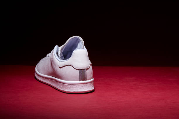 istock White Tennis Shoe - Red Background 939840320
